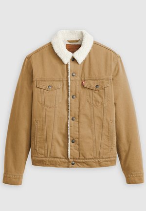 Tan denim jacket with a white sherpa collar, two chest pockets, side pockets, and metal buttons. Features vertical stitching details.