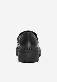 Scarpe in pelle nera con una superficie liscia, tacco arrotondato e suola in gomma spessa. Dettagli cuciti visibili al tacco.