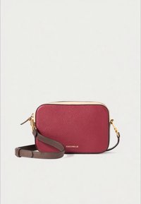 Mala tiracolo retangular em couro borgonha com ferragens douradas, alça castanha e acabamento texturizado subtil; apresenta um logótipo na frente.