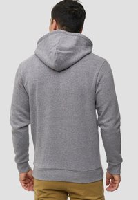 Grijze hoodie met een trekkoordcapuchon, aansluitende manchetten en een kangoeroezak. Zachte stof met een gladde textuur. Achteraanzicht.