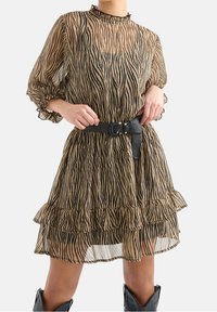 Braun und schwarz gestreiftes durchscheinendes Kleid mit Rüschensaum und -ärmeln, hohem Ausschnitt und schwarzem Gürtel-Detail.
