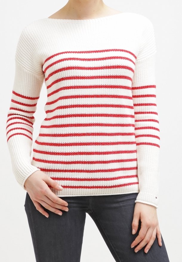 Weißer Strickpullover mit roten horizontalen Streifen, weitem Ausschnitt, langen Ärmeln und gerippten Bündchen. Getragen mit dunklen Jeans.