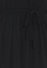 Schwarzes Stoffkleid mit geraffter Taille und gebundenem Gürtelknoten in der Mitte vorne.