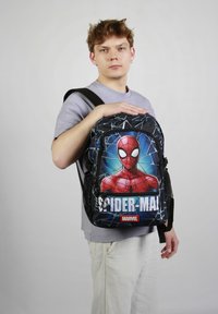 Sac à dos Spider-Man noir avec un graphisme saisissant de Spider-Man à l'avant, fabriqué en tissu durable et doté de poches latérales en maille.