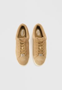 Zamszowe trampki w kolorze jasno brązowym z beżowymi sznurowadłami, okrągłym noskiem i srebrnym logo. Teksturowana cholewka i amortyzowana wkładka. Minimalistyczny design.