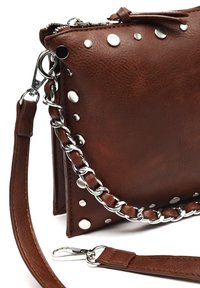 Borsa a mano in pelle marrone con borchie in argento, tracolla intrecciata e tracolla staccabile. Chiusura con zip e tirazip in pelle.