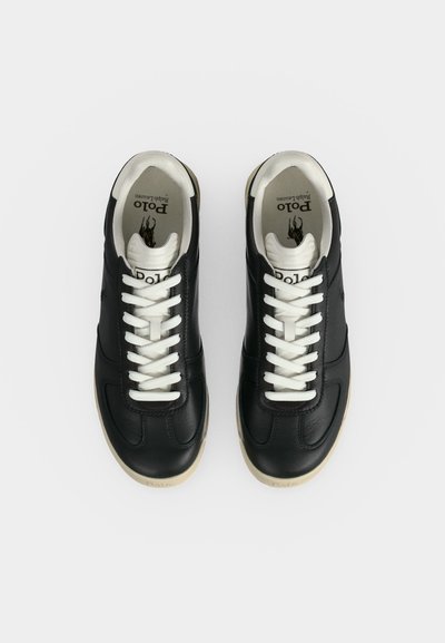 Μαύρα δερμάτινα sneakers Polo Ralph Lauren με λευκά κορδόνια και μπεζ σόλες, από επάνω σε λευκό φόντο.