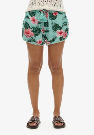 Pantaloni corti floreali in turchese chiaro con hibiscus rosa e foglie verdi. Tessuto leggero, vita elastica con lacci e orlo a onde.