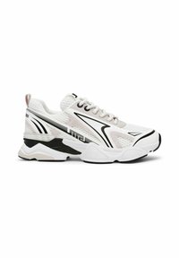 Zapatilla deportiva de malla blanca con acentos en negro y gris. Presenta una suela gruesa, superposiciones texturizadas y un sistema de cordones prominente.