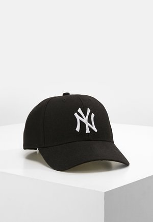 Casquette de baseball noire avec logo "NY" blanc entrelacé, posée sur une surface blanche sur fond clair uni.