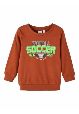 Rustfarvet langærmet sweatshirt til småbørn med teksten "FOOTBALL SOCCER 1995 PLAY THE GAME" og en grafisk fodbold på forsiden.