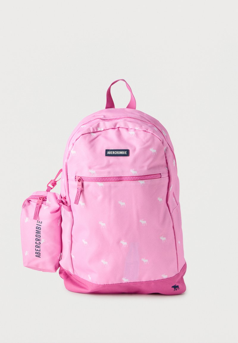 Ροζ σακίδιο πλάτης Abercrombie με λευκά σχέδια ελαφιού, μπροστινή τσέπη με φερμουάρ, συνδεδεμένη μικρή θήκη και πάνω λουράκι μεταφοράς σε λευκό φόντο.