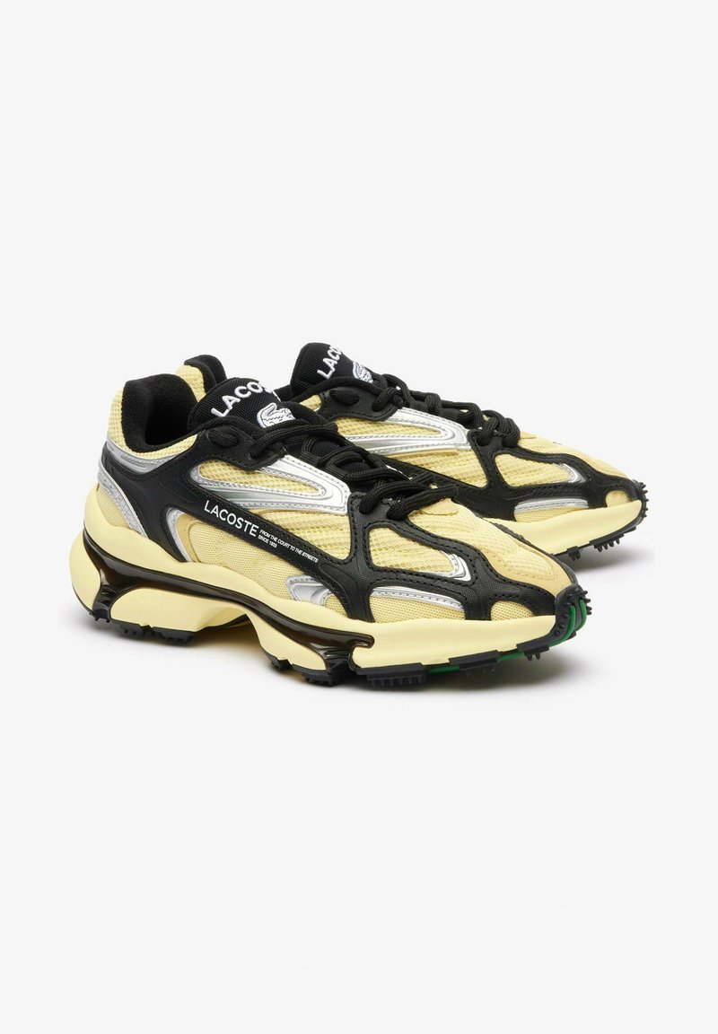 Baskets noires et jaunes en matériaux en mesh et synthétiques, avec un design unique, un col rembourré et une semelle en caoutchouc avec des accents verts.