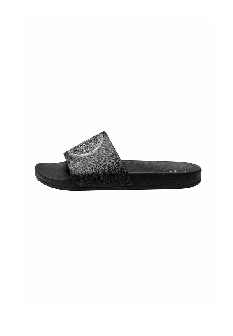Zwarte slidesandalen met een gemetalliseerde bovenband en een cirkelvormig logoaccent. De zool is plat en gemaakt van rubber voor comfort.