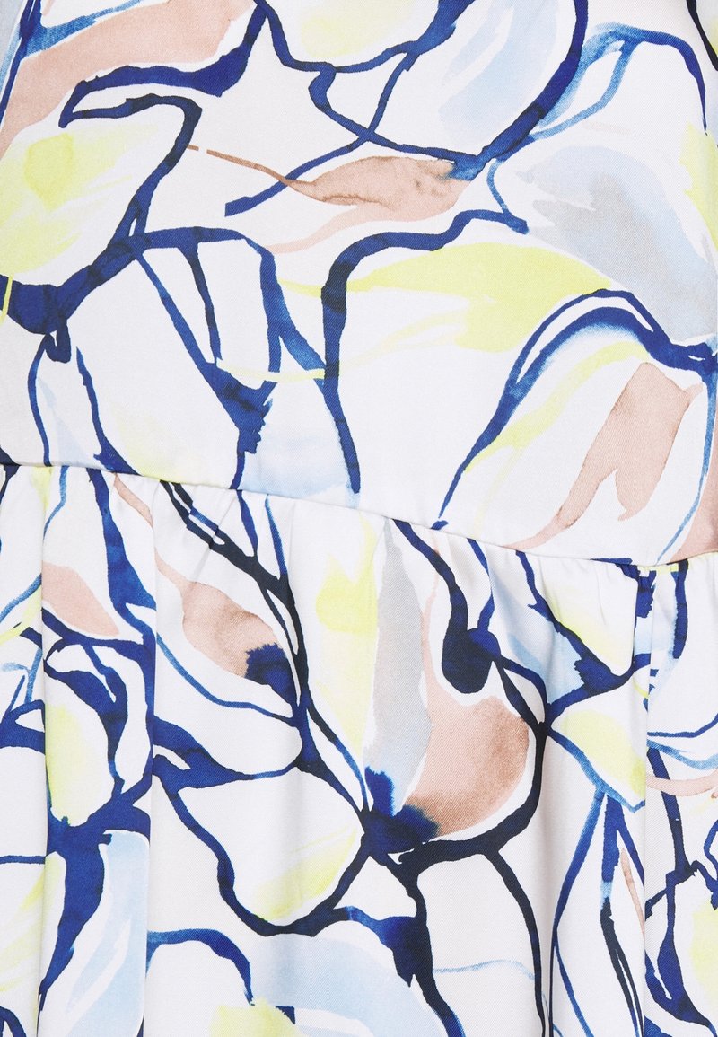 Tela con estampado floral en blanco, con tonos azules, amarillos y beiges. Textura suave con un diseño fruncido, que muestra un elegante movimiento.