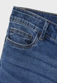 Jean en denim bleu foncé avec un design classique à cinq poches, comprenant une petite poche avant et des détails de couture contrastants.