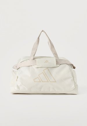 Witte sporttas met beige accenten, dubbele handvatten, zijvakken van mesh en een subtiel logo aan de voorkant.