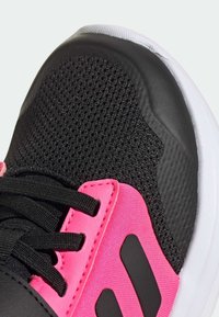Black athletic shoe featuring a breathable mesh upper, pink synthetic accents, black laces, and a white rubber sole.