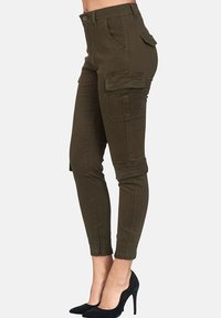 Olivgrön cargobyxor med flera fickor, figursydd design, elastiska mancuffs och knappstängning. Tillverkade av slitstarkt tyg.
