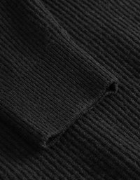 Μαύρος ριγωτός ύφασμα με υφασμάτινη επιφάνεια, που δείχνει μια κοντινή λήψη μιας διπλωμένης άκρης. Το υλικό φαίνεται μαλακό και ελαφρώς χνουδωτό.