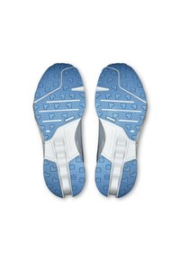 Shoe soles featuring a blue rubber with geometric tread patterns, smooth white accents, and a textured surface for enhanced grip and traction.