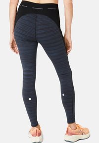 Legginsy ¾ w granatowo-czarny pasek, z wysokim stanem i odblaskowymi kropkami po bokach.