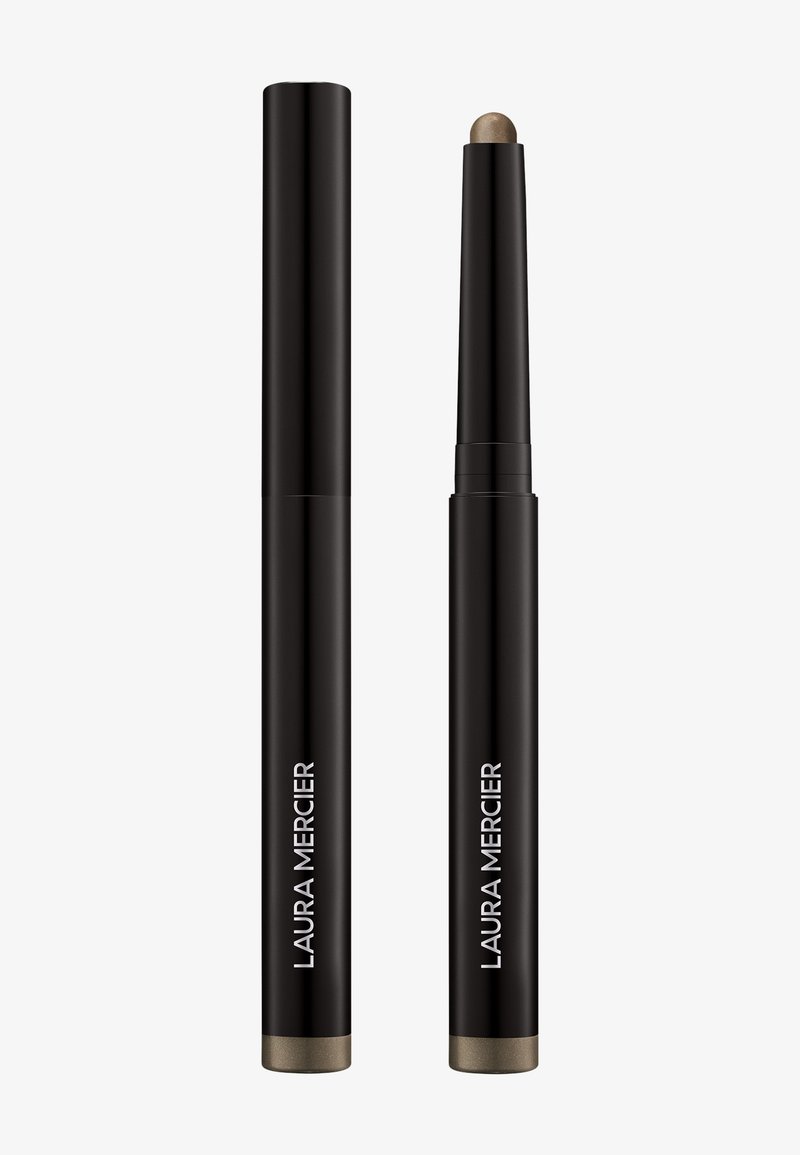 Laura Mercier øyenskygge-stift i en matt svart boks, med en metallisk bronse-spiss. Slank sylinderformet design, glatt tekstur.
