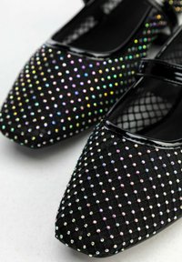 Czarne buty z tkaniny o spiczastym nosku, ozdobione wielokolorowymi cyrkoniami w kropkowy wzór, z błyszczącą czarną paskiem.