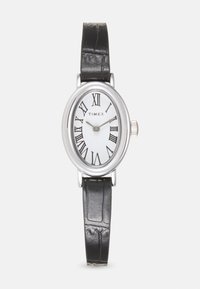 Montre ovale en argent avec un cadran blanc, des chiffres romains noirs et un bracelet en cuir noir à motif texturé. Couronne en argent sur le côté.