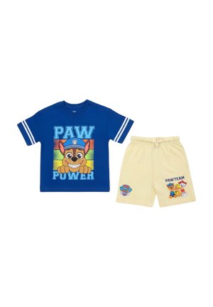 Chemise bleue à manches courtes avec « PAW POWER » et un chien de dessin animé, associée à un short jaune clair avec « PAW TEAM » et trois chiens de dessin animé.