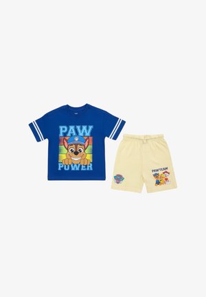 Chemise bleue à manches courtes avec « PAW POWER » et un chien de dessin animé, associée à un short jaune clair avec « PAW TEAM » et trois chiens de dessin animé.