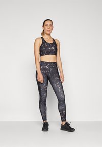 Svart marmorert sports-bh og leggings-sett, med en tettsittende design, glatt tekstur og matchende svarte joggesko.