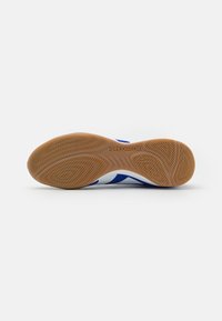 Suela de zapatilla deportiva en azul y blanco con tracción de goma de patrón, que presenta "PREDATOR" grabado en la entresuela.
