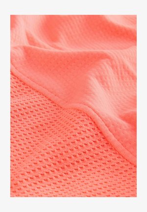Tissu de couleur corail vif, présentant une surface texturée avec un motif en grille et des zones lisses ; matériau doux et extensible.