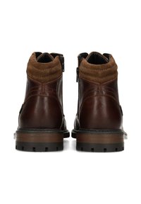 Botines de cuero marrón con puño de ante marrón en contraste, cremalleras laterales y suela de goma resistente. Acabado texturizado con detalles cosidos.