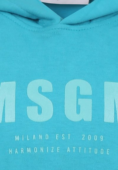 Felpa turchese con un logo frontale che riporta la scritta "MSGM" in grandi lettere bianche, con un testo più piccolo sottostante. Il tessuto sembra morbido e liscio.