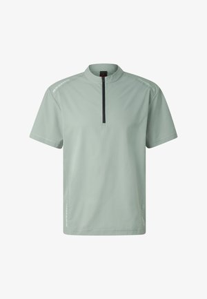 Krótka koszulka sportowa w kolorze jasnozielonym z czarnym zamkiem błyskawicznym z przodu i okrągłym kołnierzem, z subtelnymi odblaskowymi detalami na ramionach i bokach.