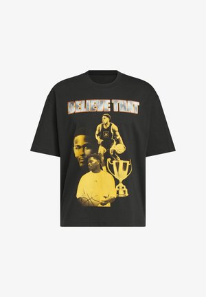 T-shirt nera con immagini gialle di giocatori di basket, un trofeo e la frase "CREDICI" in grande testo bianco e arancione.
