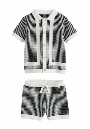 Sort-hvid strikket top med korte ærmer, knapper og krave samt matchende shorts med snøre, med et zigzag-stribet mønster.