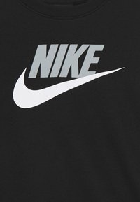 Svart sweatshirt med en framträdande vit Nike-logotyp med grå kontur, tillverkad av mjukt bomullsmaterial.