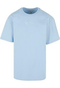 Light blue cotton t-shirt with a crew neck, short sleeves, and a white embroidered logo on the chest. Soft texture, casual fit.
