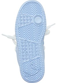 Lyseblå sneakersåle med teksturert sikksakk- og firkantmønster, hvite lisser og sirkulært emblemdetalj nær hælen.