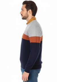 Suéter de hombre en gris, naranja y azul marino; diseño de punto con cuello redondo y manga larga. Presenta patrones de bloques de color.