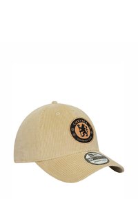 Beige Cordura-Baseballmütze mit einem runden schwarzen Patch, auf dem orangefarbener Text und das Löwenlogo des Chelsea Football Clubs abgebildet sind; gewölbter Schirm und strukturiertes Gewebe.