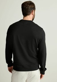 Sudadera negra con mangas largas, cuello redondo y una textura suave. Diseño minimalista sin patrones o acentos visibles.