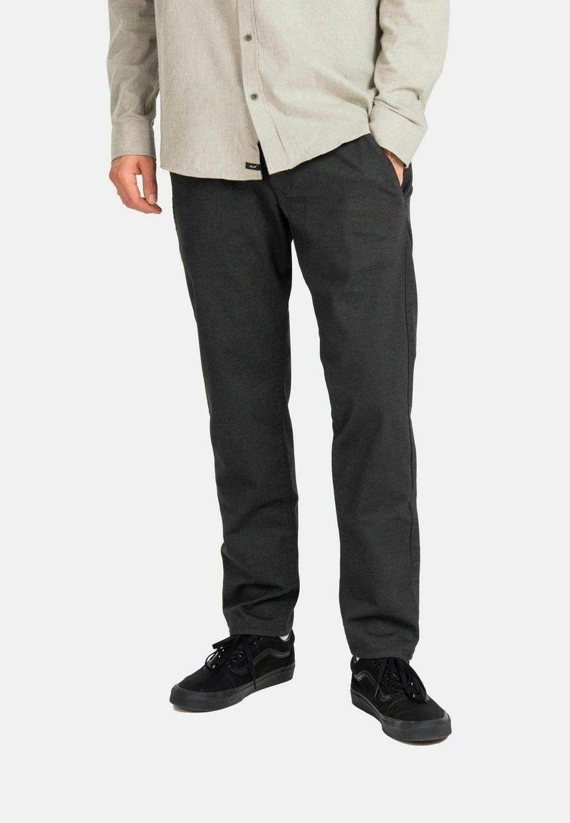 Dark gray pants made of woven fabric, featuring a straight-leg design and side pockets, paired with black sneakers and a light button-up shirt.