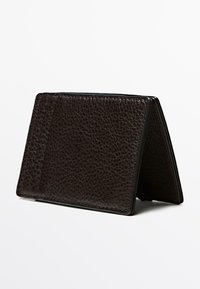 Portafoglio in pelle marrone scuro con finitura strutturata, dal design sottile e bordi lisci, posizionato in verticale per mostrare gli scomparti interni per le carte.