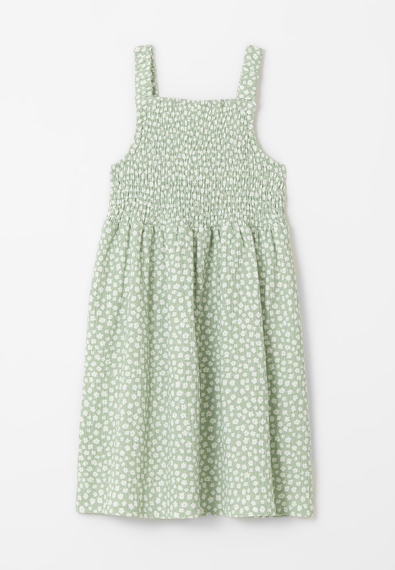 Robe sans manches vert clair avec corsage smocké et petit motif floral blanc, étalée à plat sur fond blanc.