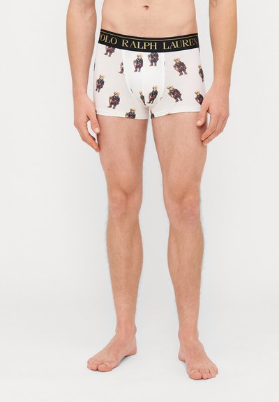 Biele boxer šortky s čiernym pásom "POLO RALPH LAUREN", s opakovaným grafickým motívom medveďa v farebných kostýmoch. Mäkko bavlnený materiál.