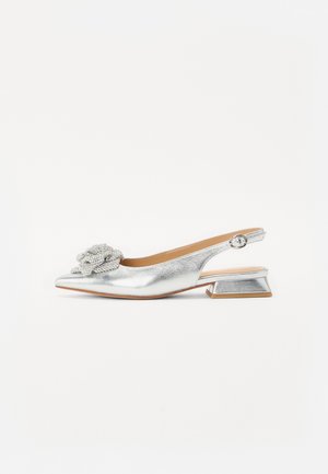 Sølv slingback lavhælet sko med spids tå og dekorativ perleblomst foran, spænde rem og metallisk tekstureret finish.